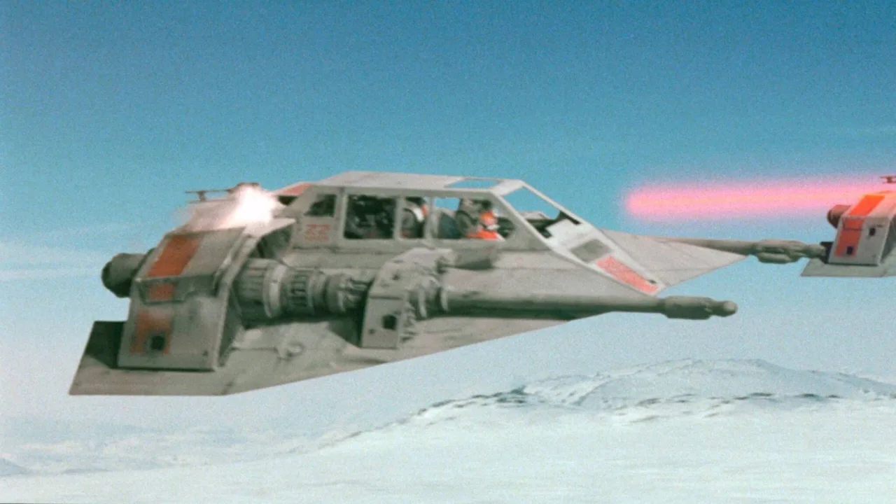 Snowspeeder original de O Império Contra-Ataca exposto em caixa de acrílico, com logotipo da Star Wars ao fundo