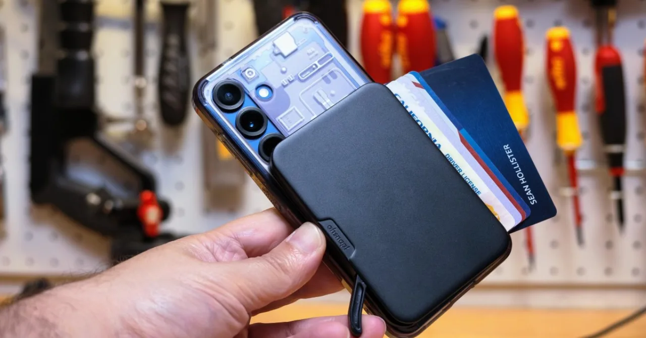 Carteira magnética OhSnap Wallet 2 de alumínio presa ao celular, exibindo a alavanca e módulos de cartões ao lado