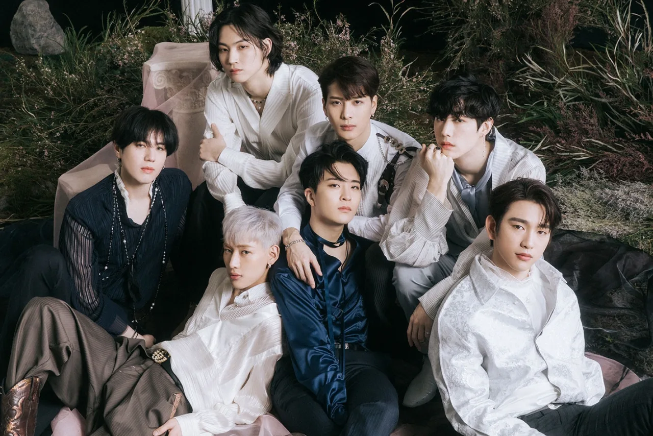 Membros do GOT7 posam ao lado do ícone do YouTube com a marca ‘100 milhões de visualizações’ sobre o clipe