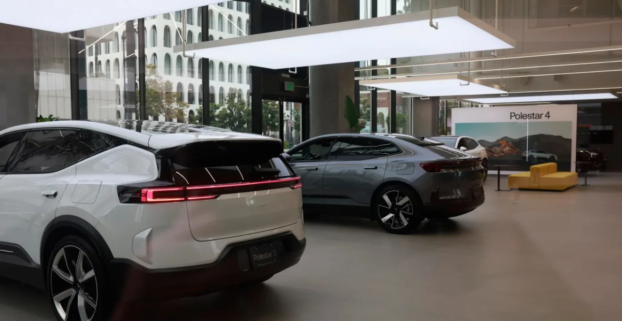 Jovem correndo ao lado de um Polestar 2 estacionado, com carregador conectado e garrafa d’água na mão
