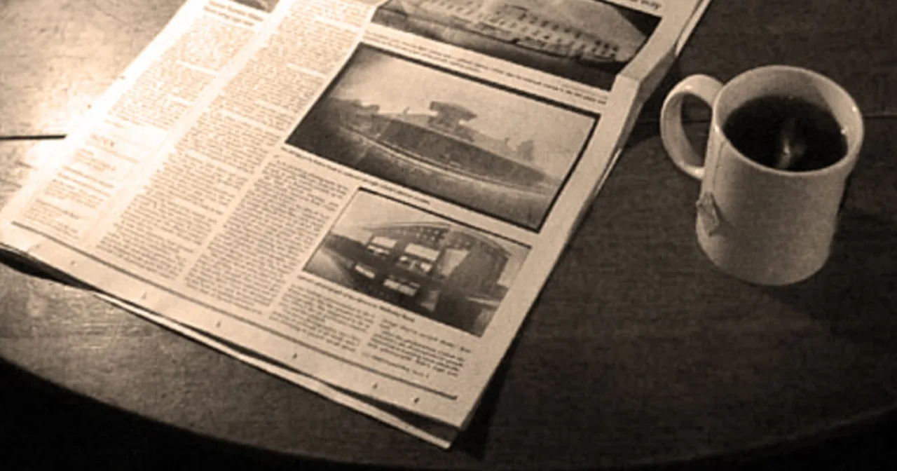 Pessoa lendo jornal com uma xícara de café