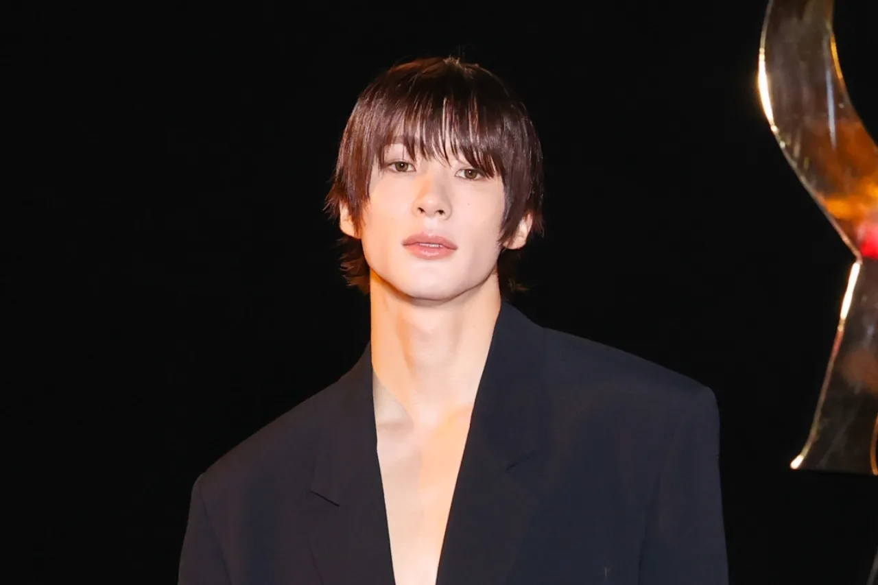 Anton, do RIIZE, desfila em traje Saint Laurent no show Spring/Summer 2027, com o logo da casa ao fundo