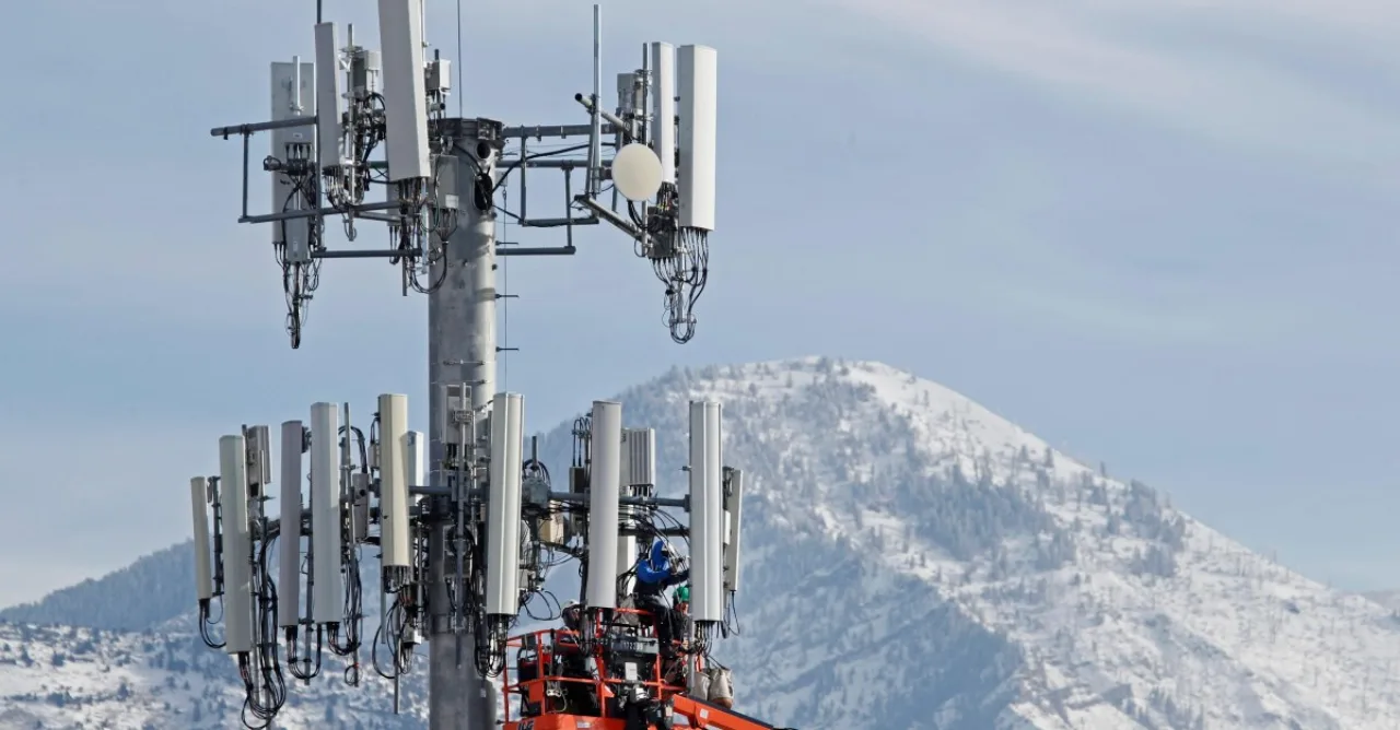 Rocket da SpaceX ao lado de torre de celular da Crown Castle, com logos das duas empresas sobre fundo azul