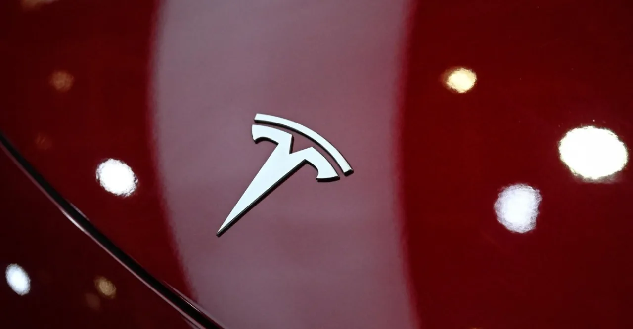 Tesla Model Y em pista, carregando em estação solar, com gráfico de vendas subindo ao fundo