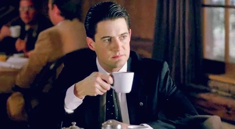 Cartão de Twin Peaks assinado por David Lynch e Kyle MacLachlan, em destaque sobre fundo escuro com o logo da série